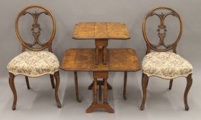 A Victorian burr walnut double Southerland table and a pair of Victorian walnut chairs.