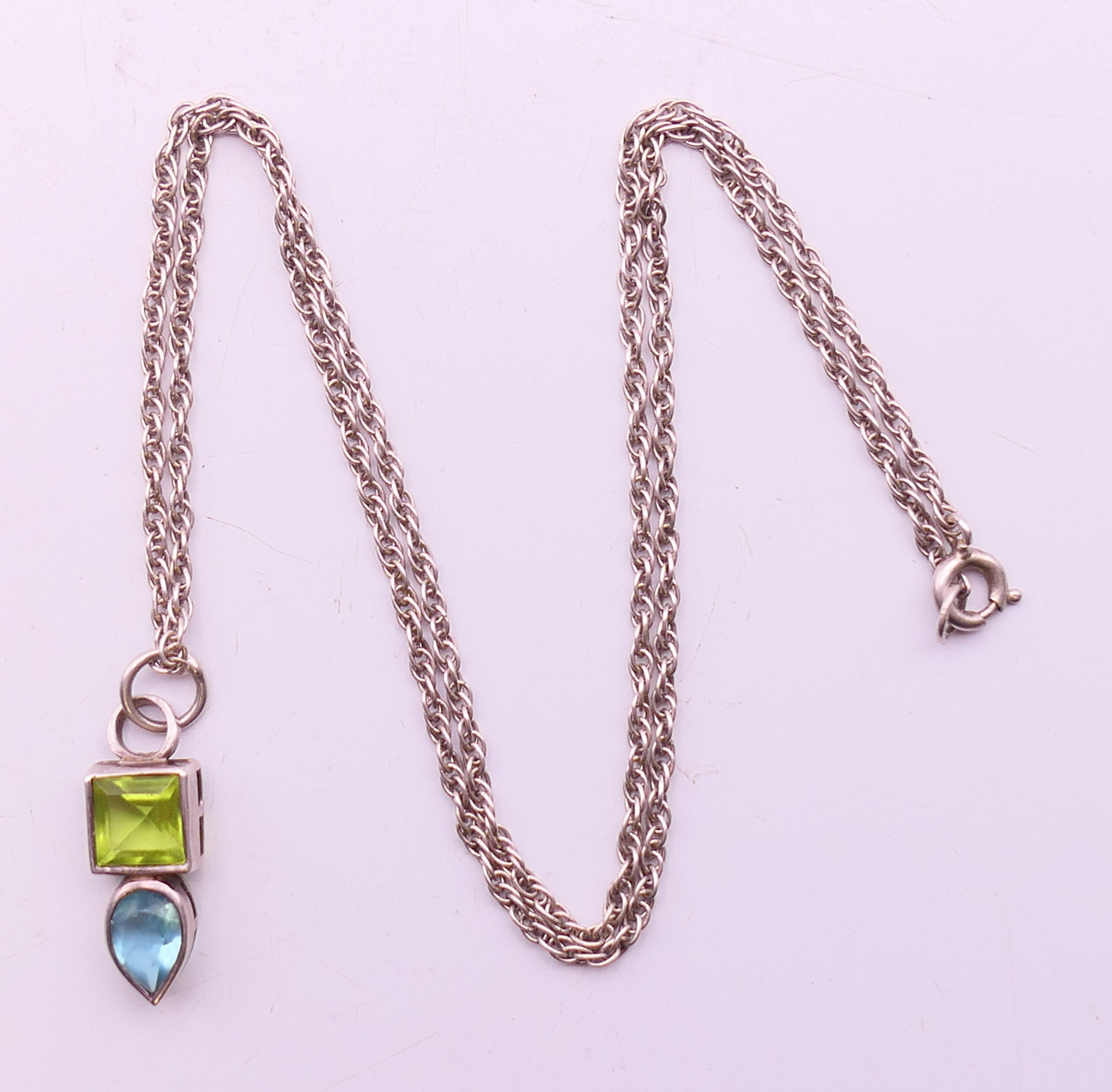 A silver peridot and blue topaz pendant and chain. Pendant 2 cm high, chain 40 cm long. - Image 4 of 5