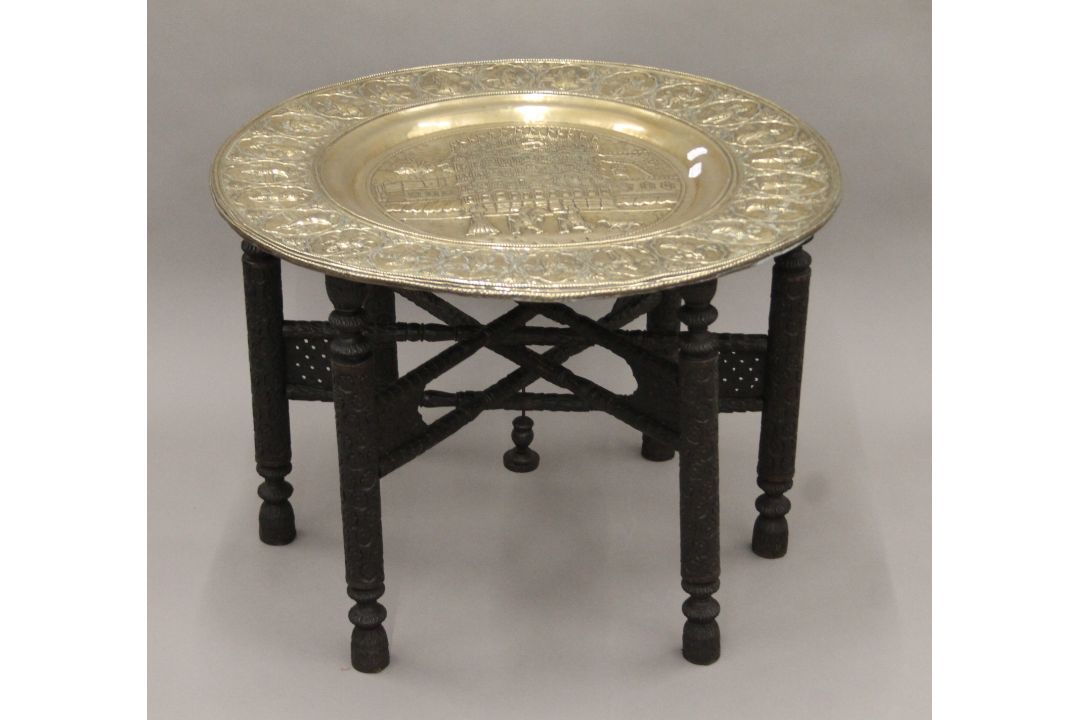 An Eastern brass-topped folding table. 75 cm diameter. - Image 1 of 5