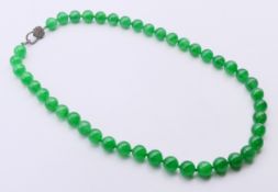 A jade and diamond heart clasp necklace. 58 cm long.