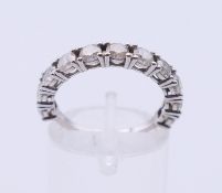 A 14 K white gold eleven-stone diamond ring (together with a gemological report). Ring size N.