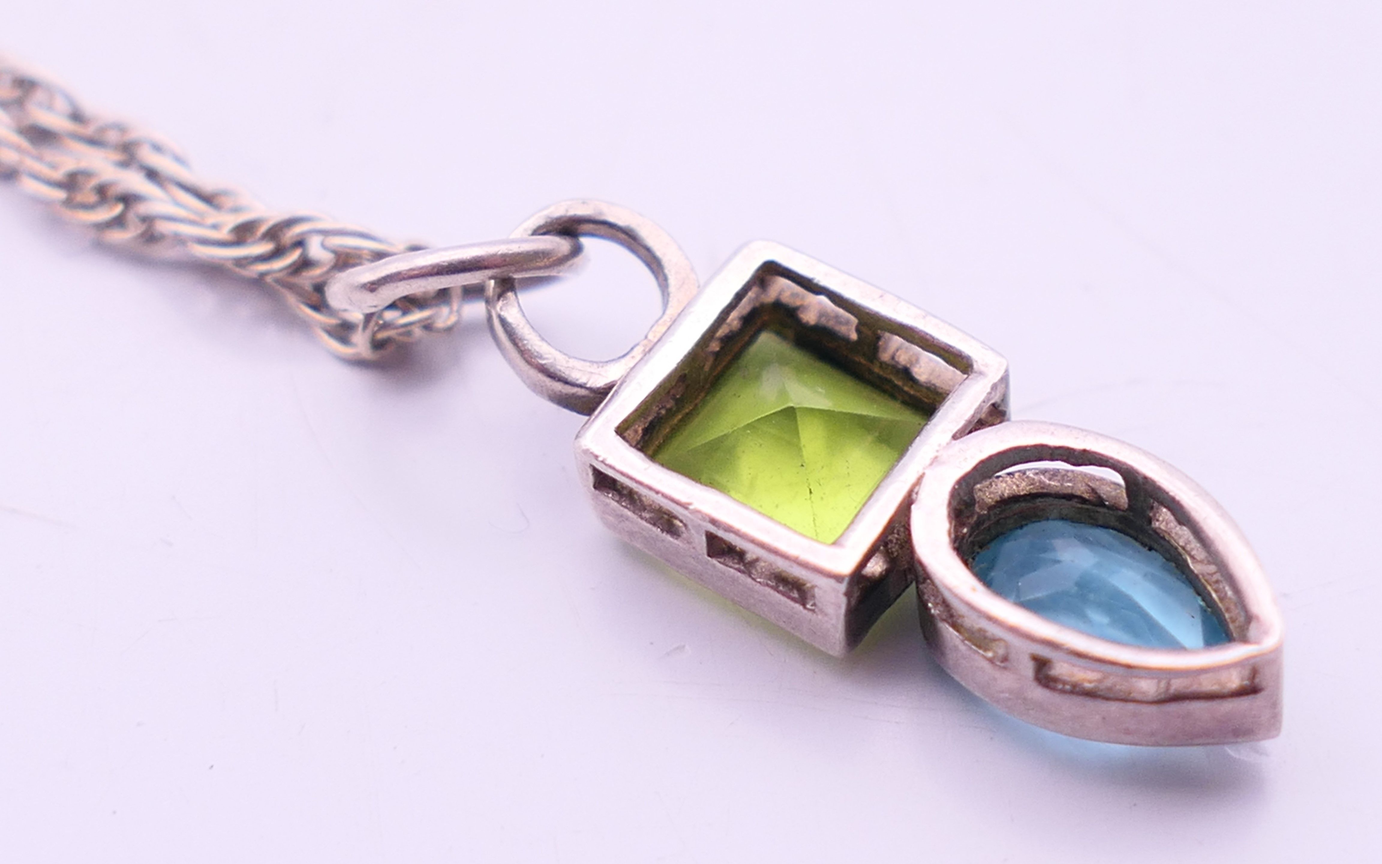 A silver peridot and blue topaz pendant and chain. Pendant 2 cm high, chain 40 cm long. - Image 3 of 5