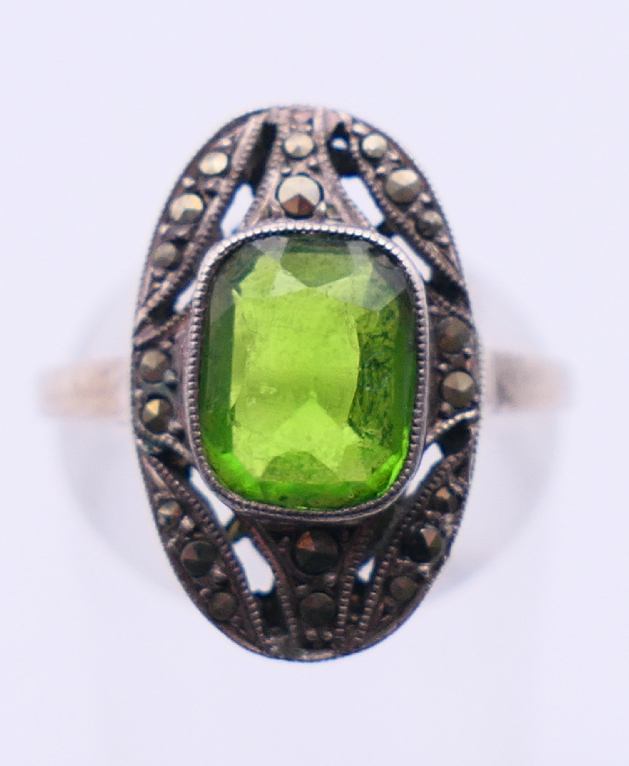 A silver marcasite and green stone ring. Ring size M/N.