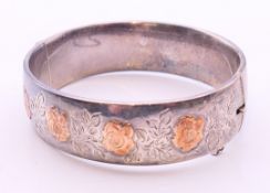 An unmarked gold mounted silver hallmarked bangle form bracelet. 6.5 cm diameter.