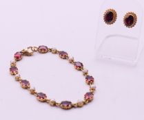 A 9 ct gold, garnet and seed pearl bracelet and a pair of 9 ct gold garnet earrings.