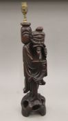 A late 19th/early 20th century Japanese carved hardwood lamp modelled as a fisherman. 57.5 cm high.