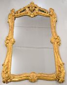 19th century gilt framed mirror with scrolling border, the top flanked by foliate swags, overall