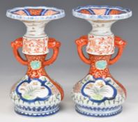 Pair of Japanese Imari twin handled pedestal vases, each decorated with birds, landscapes and