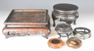 Six Chinese and Japanese stands including a large carved hardwood example with scrolling decoration,