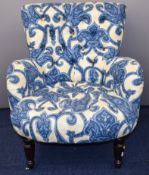 Victorian style armchair with deep buttoned seat and back, raised on turned front legs