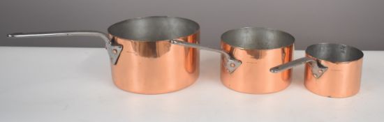 Set of three Harrods copper saucepans, length of largest 52cm