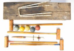Vintage croquet set with four mallets, five iron hoops and five balls, in original wooden case.