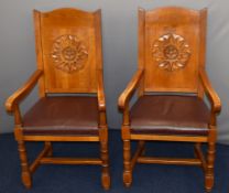 Pair of upholstered oak armchairs with carved sunburst decoration