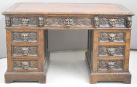 Victorian carved oak kneehole pedestal desk with mask handles, fitted nine drawers, W133 x D76 x