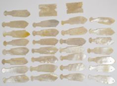 Thirty-one Chinese mother of pearl gaming counters, all but two formed as fish and 5.5cm long.