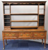 Georgian oak dresser with plate rack top flanked by two small drawers, the base fitted three drawers