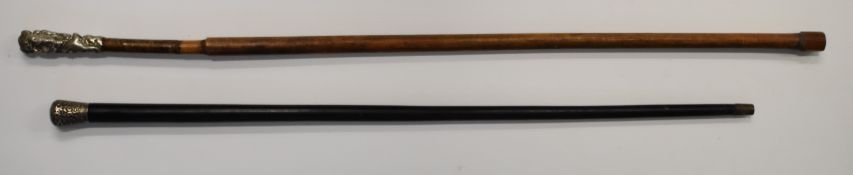 Two walking sticks with white metal finials, one Indian with embossed scrolling decoration the other