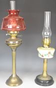 Two Victorian oil lamps, one with cranberry or similar glass shade, height of tallest 70cm