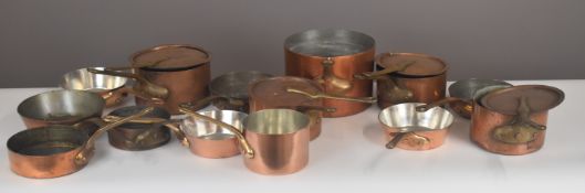 Approximately fifteen copper pans by Leon Jaeggi & Sons Ltd, London & Staines, some with lids,
