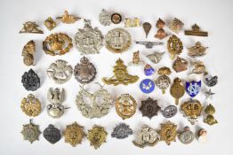 A collection of approximately thirty five military cap badges including 19th County of London St