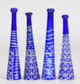 Four flash overlaid blue cut glass cheroot holders, largest 8cm long.