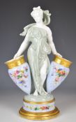Royal Worcester / Worcester figurine supporting two amphora with flower decoration, with faint
