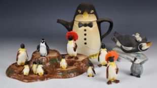A collection of novelty penguin figures including Beswick penguins with umbrellas, Franklin Mint,