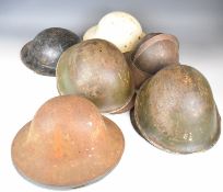 Nine WW2 era military steel helmets, including a Zuckerman stamped 3/41 to rim and 'Brodie' type