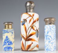 Three 19thC porcelain / glass scent / perfume bottles with hallmarked silver mounts including