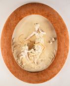 Continental porcelain plaque with figural decoration in relief of a female figure with cherub and