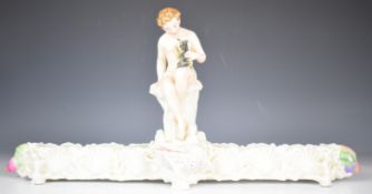 A 19thC majolica figural centrepiece / jardinière with figure holding a small dog, Phillips and