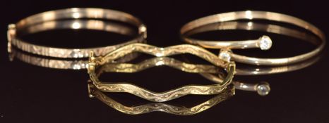 Three 9ct gold bangles, one with a wavy design, 13.9g