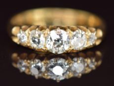 A c1900 18ct gold ring set with five diamonds, the centre diamond approximately 0.35ct, 2.9g, size