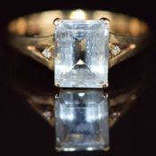 A 14k gold ring set with an emerald cut aquamarine and diamonds, 2.6g, size V