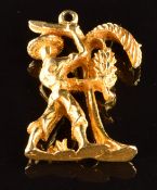 A yellow metal charm in the form of a man cutting down bananas from a tree, 8g