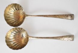 Pair of Georgian Irish hallmarked silver ladles with shell bowls and engraved decoration to the
