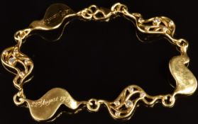 An 18ct gold bracelet made up of alternating pierced and solid wave shaped panels set with diamonds,