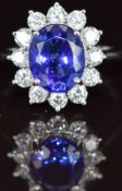 A platinum ring set with an oval cut tanzanite of approximately 3.6ct surrounded by twelve round cut