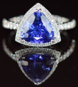 A platinum ring set with a trilliant cut tanzanite of approximately 3.3ct surrounded by diamonds,