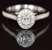 Jenny Packham 18ct white gold ring set with an oval cut diamond surrounded by further diamonds,