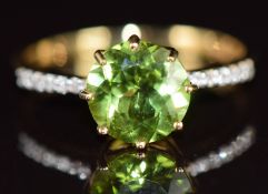 An 18k gold ring set with a round cut Kashmir peridot of approximately 1.9ct, with diamond encrusted