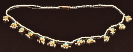 A c1900 single strand of seed pearls with 13 gold pendants set with turquoise and further seed