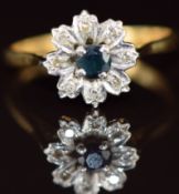 An 18ct gold ring set with a round cut sapphire surrounded by diamonds in a floral cluster, 3.1g,