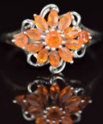 A 9ct gold ring set with fire opals in a cluster, 2.5g, size R