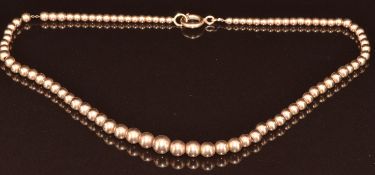 A 9ct rose gold necklace made up of graduated round beads, 12.6g, 36cm