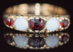 A 9ct gold ring set with opals and garnets, 2.6g, size O