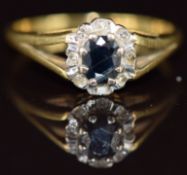 An 18ct gold ring set with an oval cut sapphire surrounded by diamonds, 2.5g, size J