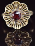 A 9ct gold ring set with a garnet in a floral setting, 4.4g, size M