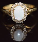 An 18ct gold ring set with an opal surrounded by diamonds, 5g, size P