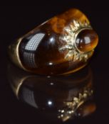 A 9k gold ring set with tiger's eye with a star setting to the centre set with a tiger's eye